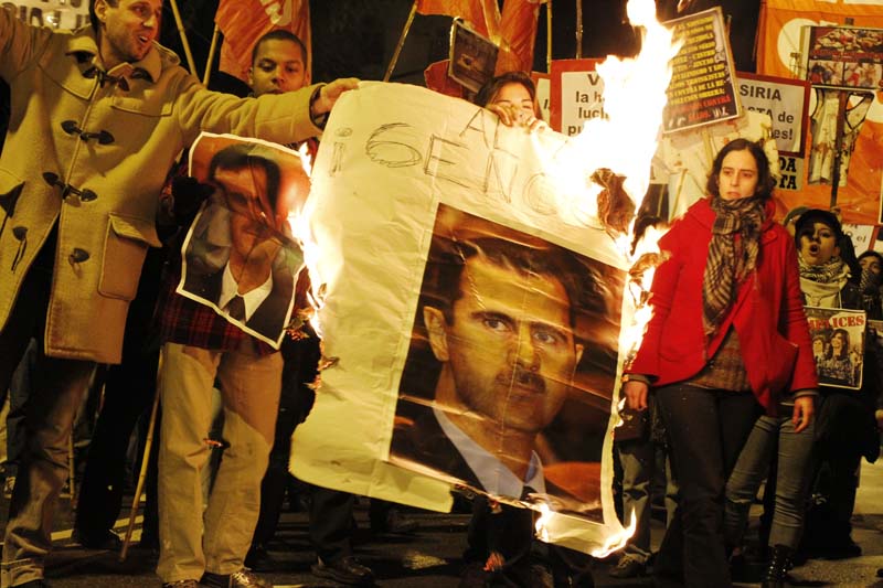 Argentina: un cartel con el rostro del genocida Al Asad arde mientras los manifestantes cantan consignas contra su régimen