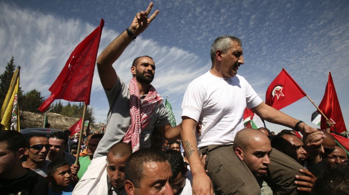 Samer Tareq al-Issawi (izq.) es llevado en andas después de haber sido liberado el 18 de octubre 2011 en Jerusalén. (AP Photo / Awad Muammar)
