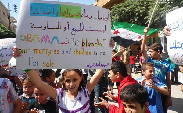 La pancarta dice: "Obama, la sangre de nuestros mártires y nuestros niños no está en venta" y es de una manifestación en Siria el 13-9-2013