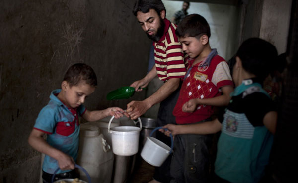 Varios niños recogen la comida dada por una organización benéfica en el barrio de Bustan al-Qaser. J.M. LÓPEZ