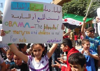 La pancarta dice: "Obama, la sangre de nuestros mártires y nuestros niños no está en venta" y es de una manifestación en Siria el 13-9-2013