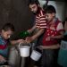 Varios niños recogen la comida dada por una organización benéfica en el barrio de Bustan al-Qaser. J.M. LÓPEZ